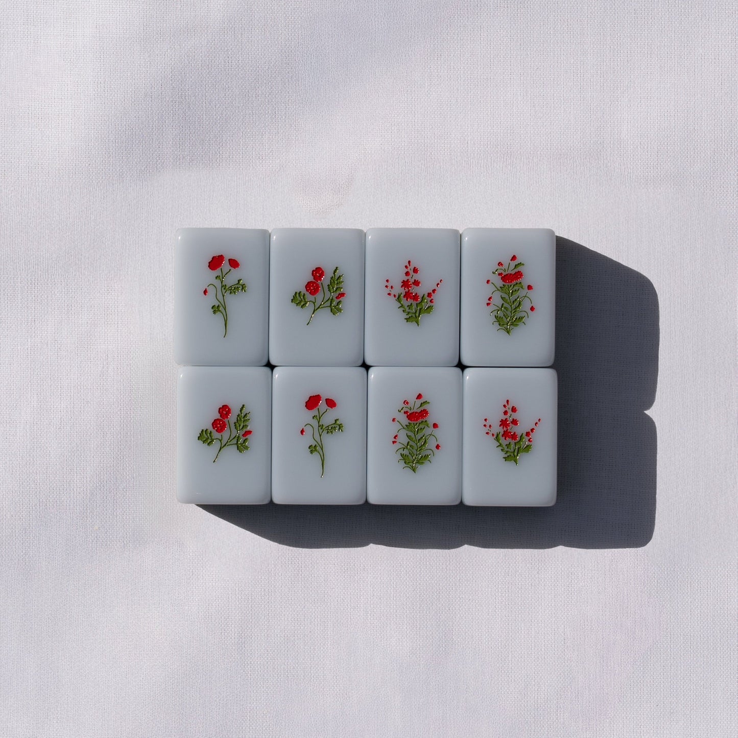 Set of light blue mahong tiles with flower icons.