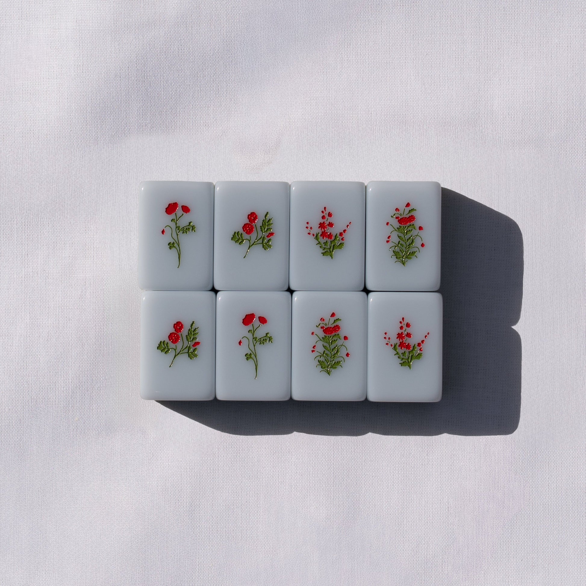 Set of light blue mahong tiles with flower icons.