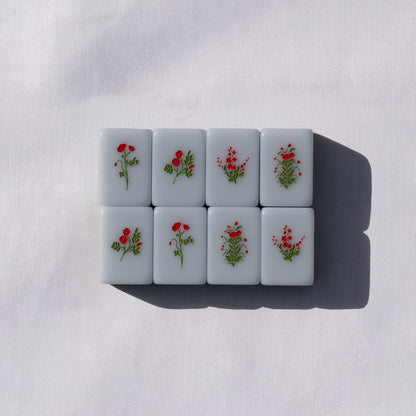 Set of light blue mahong tiles with flower icons.