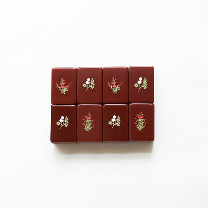 Set of red mahjong tiles with floral designs on a white background